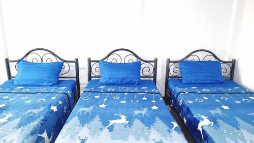 a bedroom with two beds with blue comforters at Apartment near Central Festival Hatyai in Hat Yai