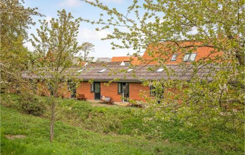 a red brick house on a hill with trees at Stunning Apartment In Svaneke With Wifi in Svaneke