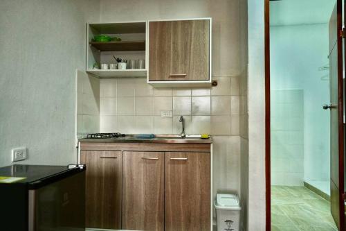 a small kitchen with wooden cabinets and a sink at Apartaestudios la terraza 2 in Sincelejo
