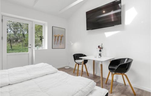 a bedroom with a bed and a table and chairs at 1 Bedroom Gorgeous Apartment In Svaneke in Svaneke