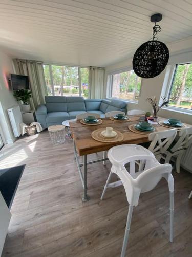 a living room with a table and a couch at Luxe groot chalet voor 6 personen op de Veluwe! in Doornspijk