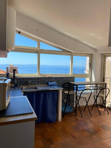 une cuisine avec une table et des chaises et une fenêtre dans l'établissement Pacini, à Bonifacio