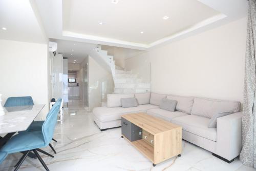 a living room with a white couch and a table at Villa Paradisio - Pool, Sea View, 4bdrms,BBQ in Hanioti