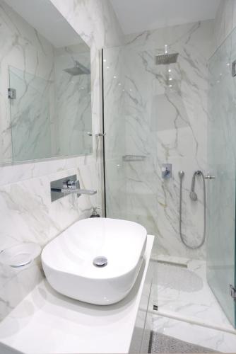 a white bathroom with a sink and a shower at Villa Paradisio - Pool, Sea View, 4bdrms,BBQ in Hanioti