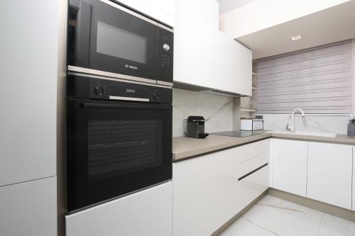a kitchen with a microwave and a black oven at Villa Paradisio - Pool, Sea View, 4bdrms,BBQ in Hanioti