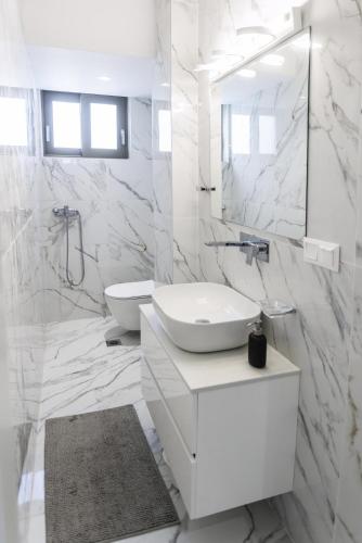 a white bathroom with a sink and a mirror at Villa Paradisio - Pool, Sea View, 4bdrms,BBQ in Hanioti
