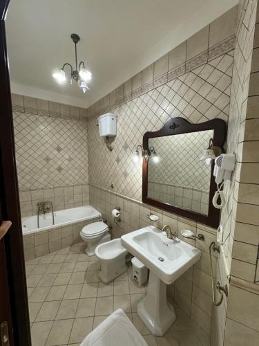 a bathroom with a sink and a toilet and a mirror at Vittoria's home near Maradona mural in Naples