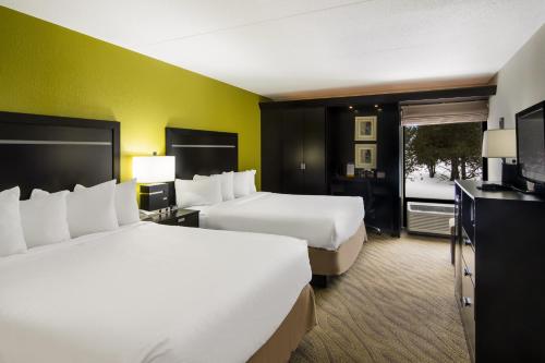 a hotel room with two beds and a television at Comfort Inn in Cadillac