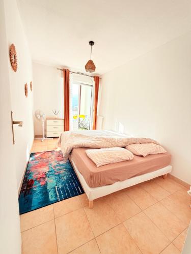 - une chambre avec un lit et un tapis coloré au sol dans l'établissement Bastia vue Mer et Montagne, à Bastia