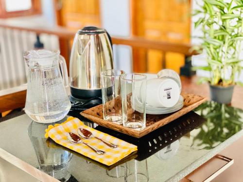a table with a tea kettle and glasses on it at 2V Villa, In Habaraduwa City, Near Unawatuna and Thalpe beach, Koggala Airport and Lagoon, Galle Dutch Fort, in Habaraduwa