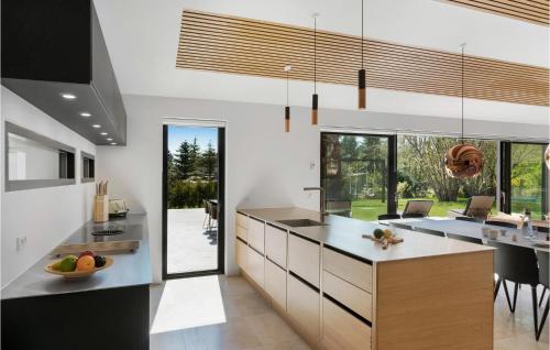 a kitchen with a large island and a dining room at Lovely Home In Græsted With Sauna in Græsted