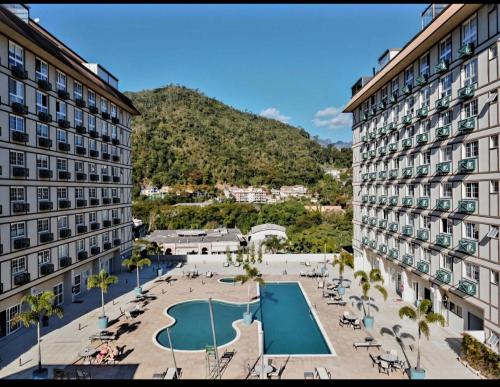 vue aérienne d'un hôtel avec une piscine entre deux bâtiments dans l'établissement Estúdios Em Itaipava - Granja Brasil - Conforto e Lazer, à Itaipava