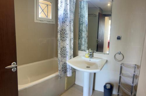 a bathroom with a sink and a tub and a mirror at Sea view apartment Mogador in Essaouira