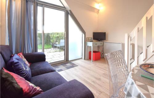 a living room with a couch and a large window at Beautiful Home In Montmartin-Sur-Mer in Montmartin-sur-Mer