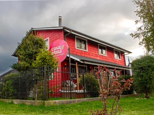 a red building with a sign on the side of it at Hotel Boutique Casa&Alma in Puerto Varas