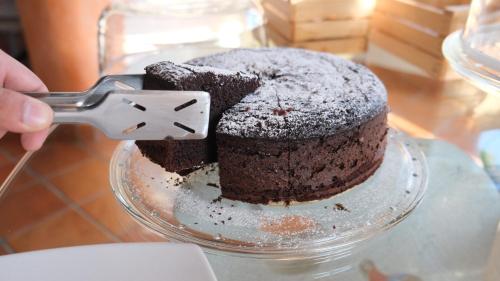 a person holding a spatula cutting into a chocolate cake at B&B Bella Peschici in Peschici