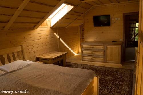 a bedroom with a bed and a television in a cabin at Eco Sadyba Familia in Yaremche