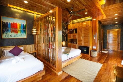 two beds in a room with wooden walls at Andalay Beach Resort Koh Libong in Ko Libong