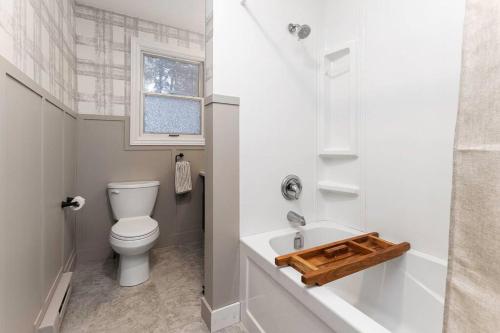 a white bathroom with a toilet and a sink at 4Bdrm Muskoka Retreat, Fire Table, Games, Netflix in Port Carling