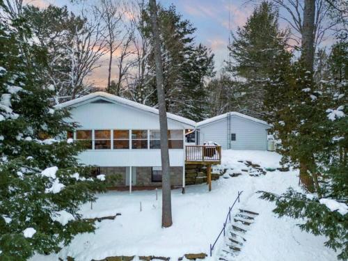 a house in the snow with trees in the yard at 4Bdrm Muskoka Retreat, Fire Table, Games, Netflix in Port Carling