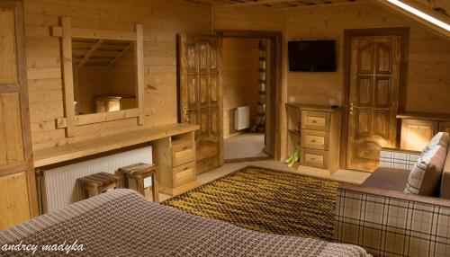 a living room with a couch in a wooden cabin at Eco Sadyba Familia in Yaremche