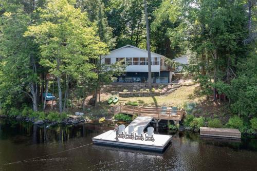 a large house with a dock in the water at 4Bdrm Muskoka Retreat, Fire Table, Games, Netflix in Port Carling