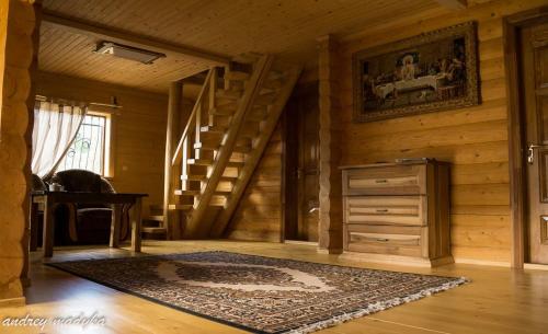 a room with a staircase in a wooden house with a rug at Eco Sadyba Familia in Yaremche