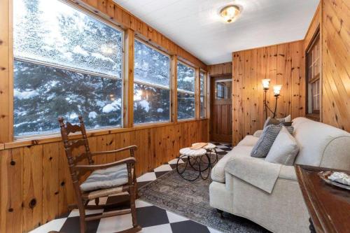 a living room with wooden walls and a couch and windows at 4Bdrm Muskoka Retreat, Fire Table, Games, Netflix in Port Carling
