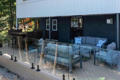 a glass table and chairs on a patio at 4Bdrm Muskoka Retreat, Fire Table, Games, Netflix in Port Carling