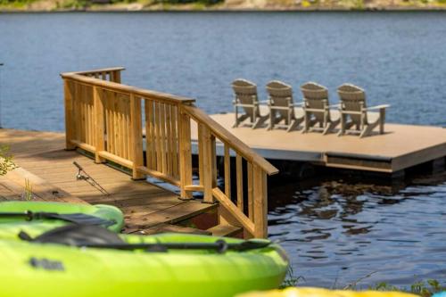 a dock with chairs and a table and some water at 4Bdrm Muskoka Retreat, Fire Table, Games, Netflix in Port Carling