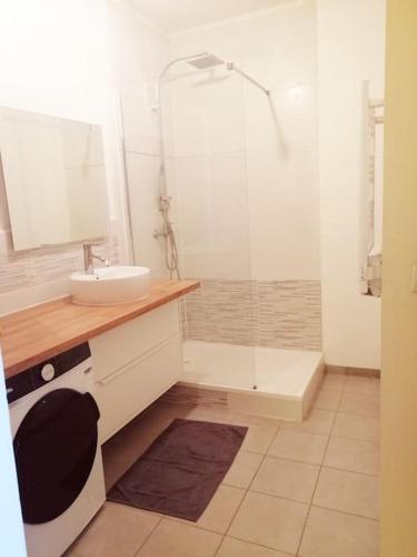 une salle de bain blanche avec une douche et un lavabo dans l'établissement Un joli chez vous à Sète, à Sète