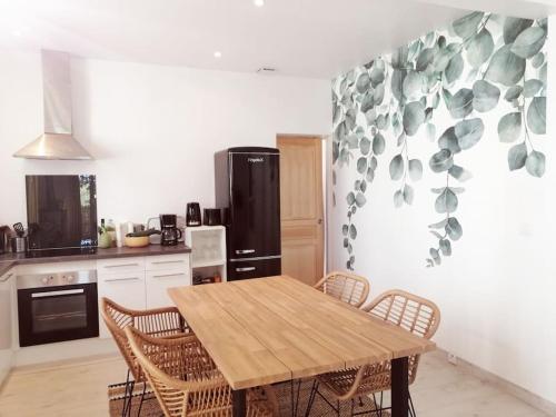 une cuisine avec une table et des chaises en bois dans l'établissement Un joli chez vous à Sète, à Sète