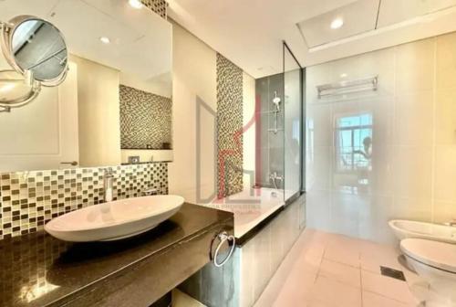 a large bathroom with two sinks and a shower at 1br - 5 min from Burj Khalifa and Mall - Best view in Dubai