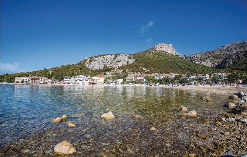 a beach with rocks in the water with mountains in the background at 3 Bedroom Awesome Apartment In Klek in Klek