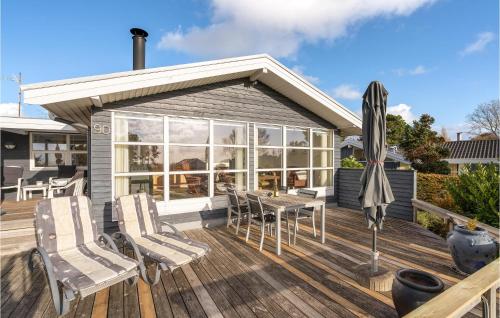 a patio with chairs and an umbrella on a deck at Three-Bedroom Holiday Home In Sydals in Østerby