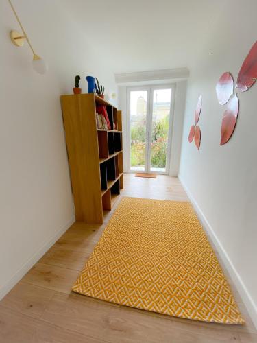 un couloir avec un tapis jaune au sol dans l'établissement Le Notre Dame maison spacieuse avec jardin, à Calais
