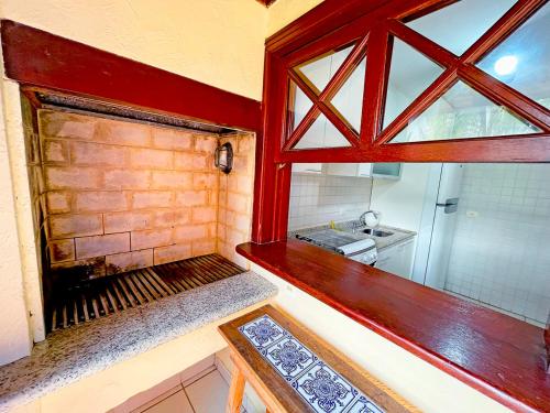 a small kitchen with a window and a sink at Canto do mar Maresias in Maresias