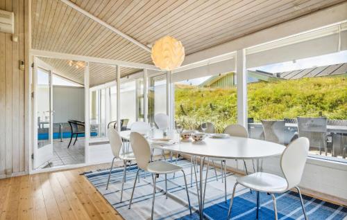 a dining room with a white table and chairs at Pet Friendly Home In Pandrup With Sauna in Blokhus