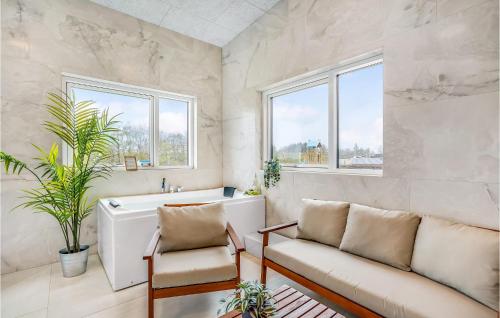 a living room with a couch and a bath tub at Lovely Home In Løgstrup With Wifi in Løgstrup
