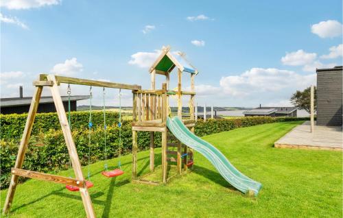 a wooden playground with a slide in a yard at Lovely Home In Løgstrup With Wifi in Løgstrup