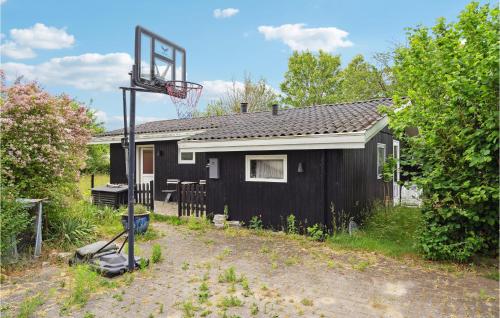 a black house with a basketball hoop in front of it at Beautiful Home In Karrebæksminde in Karrebæksminde