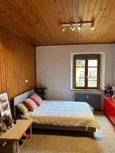 une chambre avec un lit et un plafond en bois dans l'établissement Appartement Hohwald terrasse 101, au Hohwald