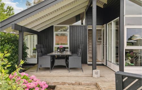 a screened in porch with a table and chairs at 2 Bedroom Stunning Home In Odder in Odder