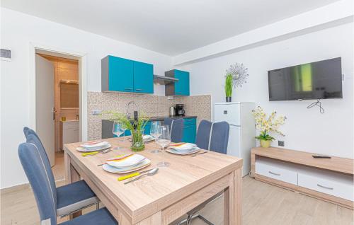 a dining room with a wooden table and blue chairs at 1 Bedroom Lovely Apartment In Brodarica in Brodarica
