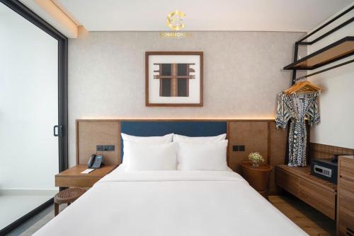 a bedroom with a large white bed and a window at Apec Boutique Hotel Phú Yên in Tuy Hoa