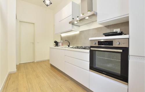 eine Küche mit weißen Schränken und einem schwarzen Backofen in der Unterkunft Gorgeous Apartment In Balestrate in Balestrate