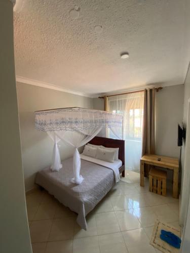 a bedroom with a bed with a canopy at Occazia Hotel in Mbarara