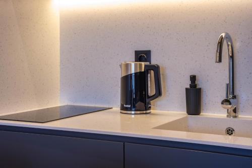 a coffee maker sitting on a counter next to a sink at New Gudauri Neo Apartments in Gudauri
