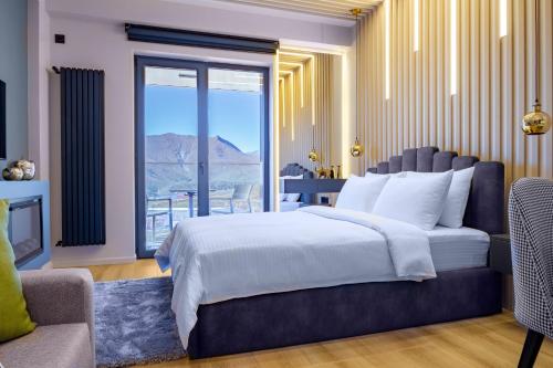 a bedroom with a large bed and a large window at New Gudauri Neo Apartments in Gudauri