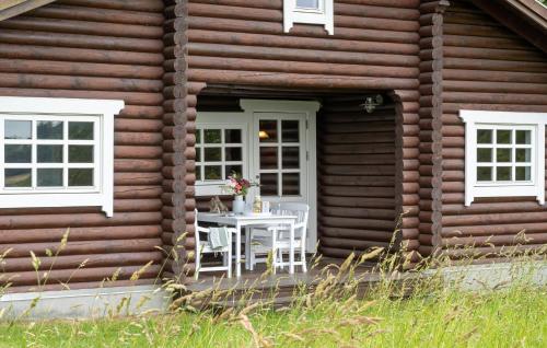 a wooden house with a table and chairs on the porch at 2 Bedroom Cozy Home In Mariager in Mariager